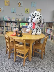 Large spotted toy dog sitting on a library table