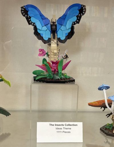Lego models of a blue butterfly, a green praying mantis, and a yellow beetle.